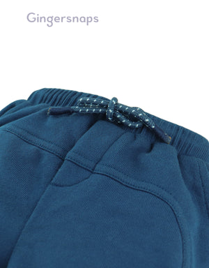 Flatlay front view of the Baby Wes Curved Panel Jogger Pants in blue showing the jogger silhouette and panel details from the Streetwear Inspired collection of Filipino kids fashion brand Gingersnaps.